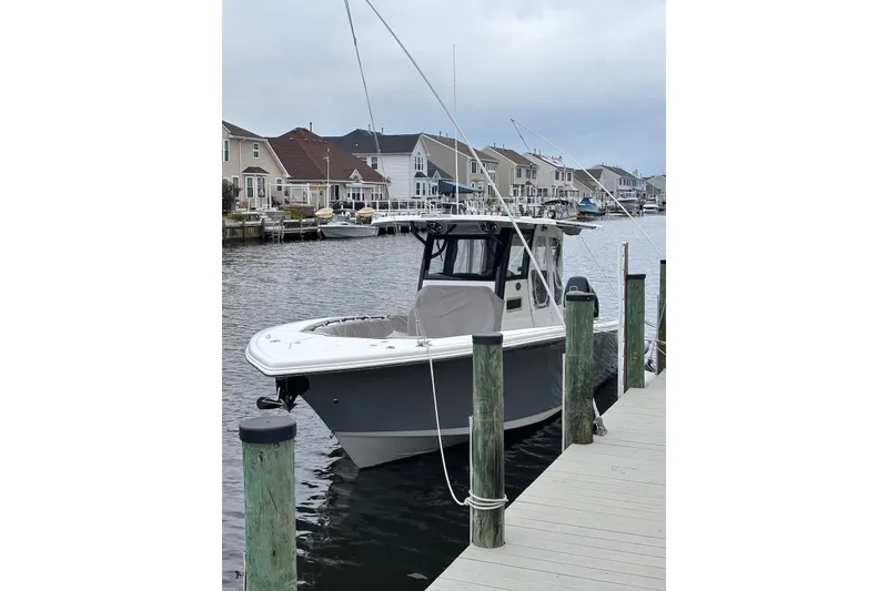 The Image of 2021 Sea Pro 320 DLX Center Console boat docked in a residential marina. - 0