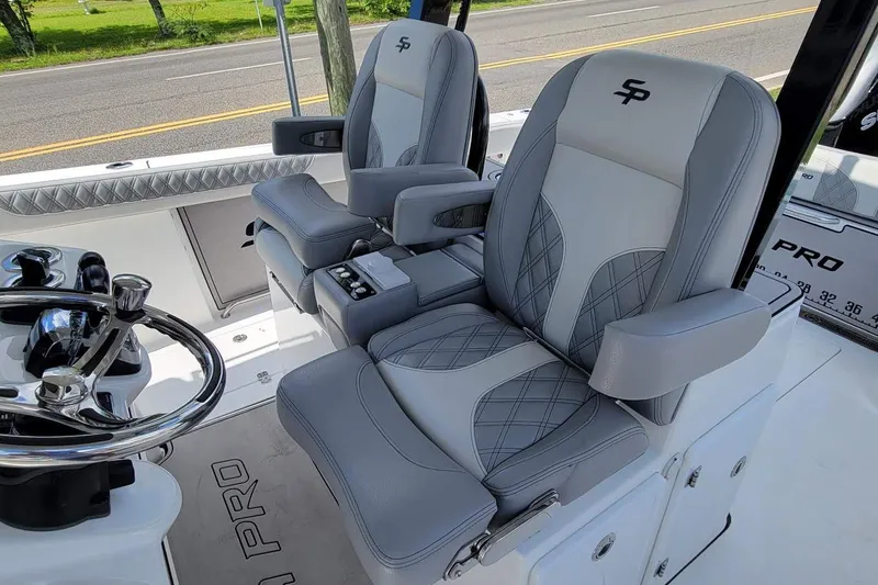 Slide: The Image of 2021 Sea Pro 320 DLX Center Console boat with luxurious gray seating and steering wheel. - 10