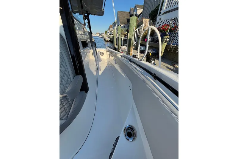 Slide: The Image of 2021 Sea Pro 320 DLX Center Console boat docked, showcasing sleek design and waterfront view. - 14