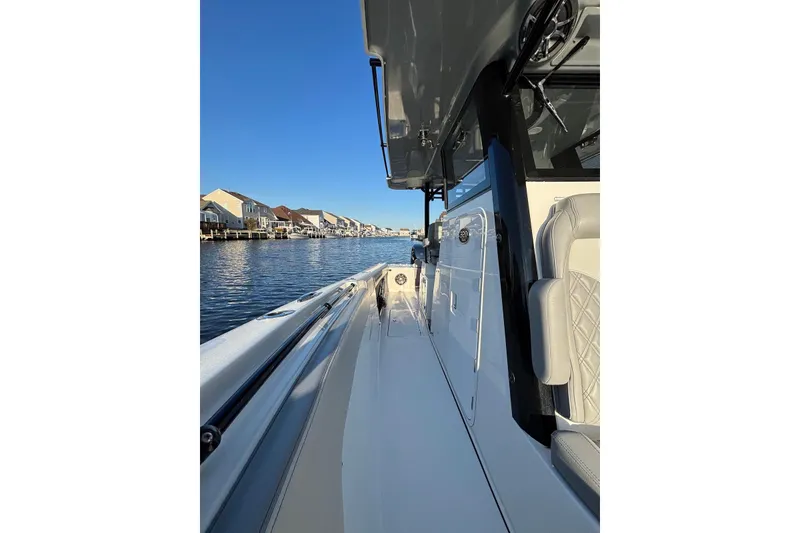 Slide: The Image of 2021 Sea Pro 320 DLX Center Console boat on calm water, showcasing sleek design. - 15