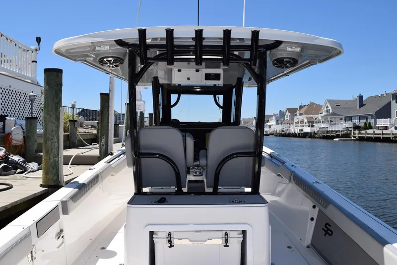 Slide: The Image of 2021 Sea Pro 320 DLX Center Console boat docked by waterfront homes. - 20
