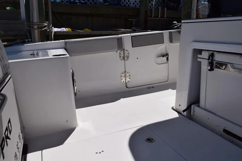 Slide: The Image of 2021 Sea Pro 320 DLX Center Console boat interior, featuring sleek white deck and storage compartments. - 24