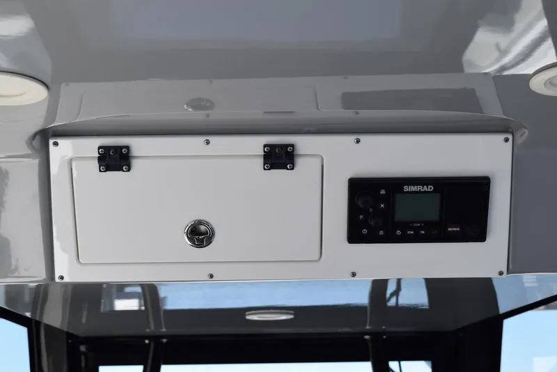Slide: The Image of 2021 Sea Pro 320 DLX Center Console dashboard with Simrad electronics and storage compartment. - 28
