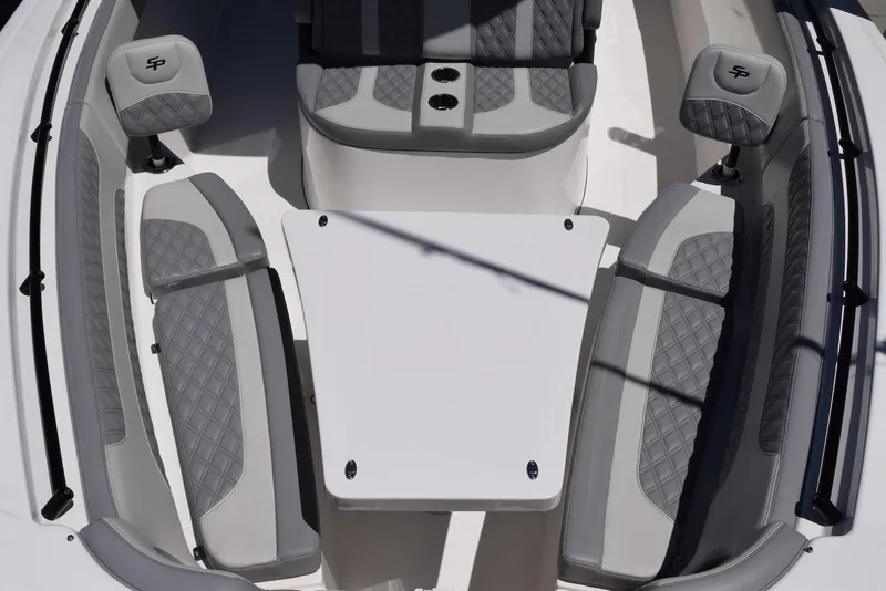 Slide: The Image of 2021 Sea Pro 320 DLX Center Console boat interior with gray seating and table. - 29
