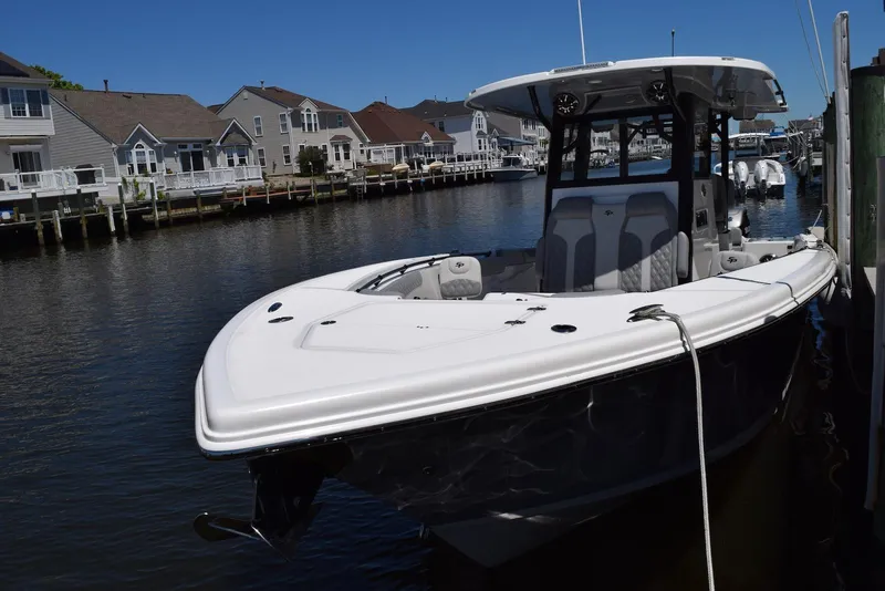 Slide: The Image of 2021 Sea Pro 320 DLX Center Console boat docked in a scenic waterfront neighborhood. - 32