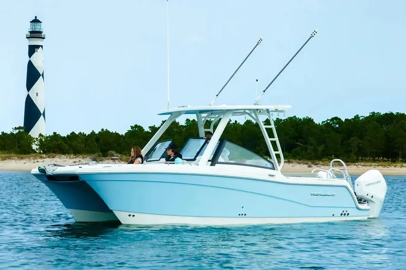 Slide: The Image of Manufacturer Provided Image: 2026 World Cat 265 DC-X boat cruising near a lighthouse on calm waters. - 1