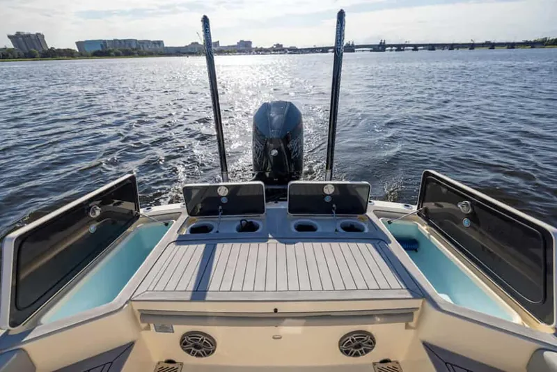 Slide: The Image of Manufacturer Provided Image: 2025 Scout 281 XSS boat on water, rear view with motor and open compartments. - 11