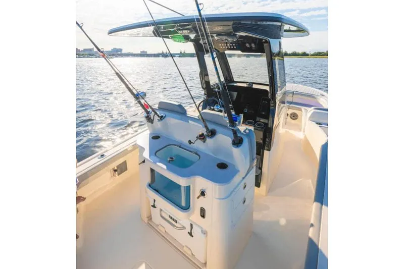 Slide: The Image of Manufacturer Provided Image: 2025 Scout 281 XSS boat interior with fishing rods on a sunny day. - 12
