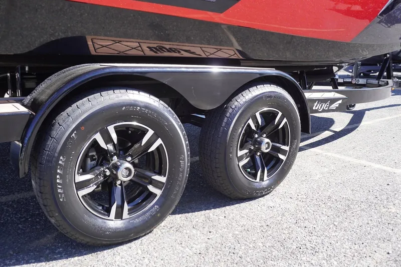 Slide: The Image of 2022 Tigé 22RZX boat trailer with dual black alloy wheels on pavement. - 12