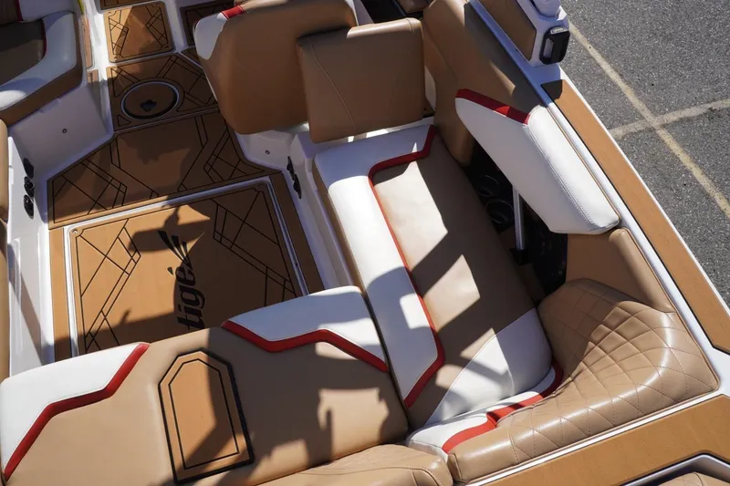 Slide: The Image of 2022 Tigé 22RZX boat interior with tan and white seating, red accents, and geometric flooring. - 18