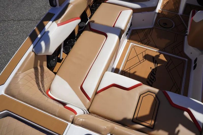 Slide: The Image of 2022 Tigé 22RZX boat interior with tan and white seating, red accents, and custom flooring. - 20