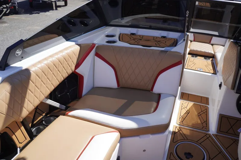 Slide: The Image of 2022 Tigé 22RZX boat interior with tan and white seating, diamond stitching, and cup holders. - 21
