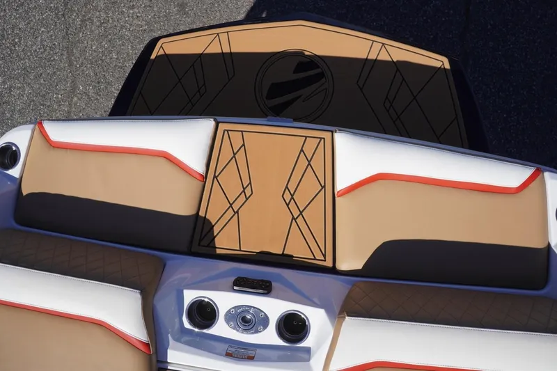 Slide: The Image of 2022 Tigé 22RZX boat interior with tan and white upholstery, red accents, and geometric design. - 26
