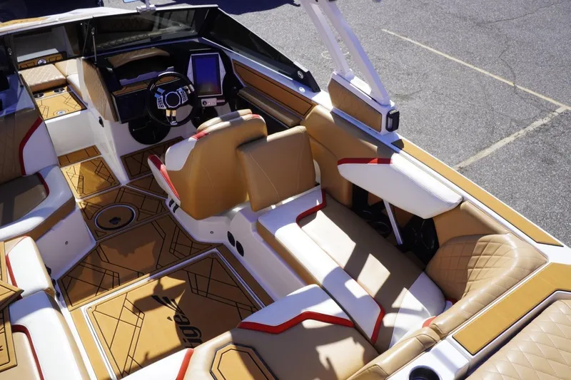 Slide: The Image of 2022 Tigé 22RZX boat interior with tan and red upholstery, modern dashboard, and spacious seating. - 28