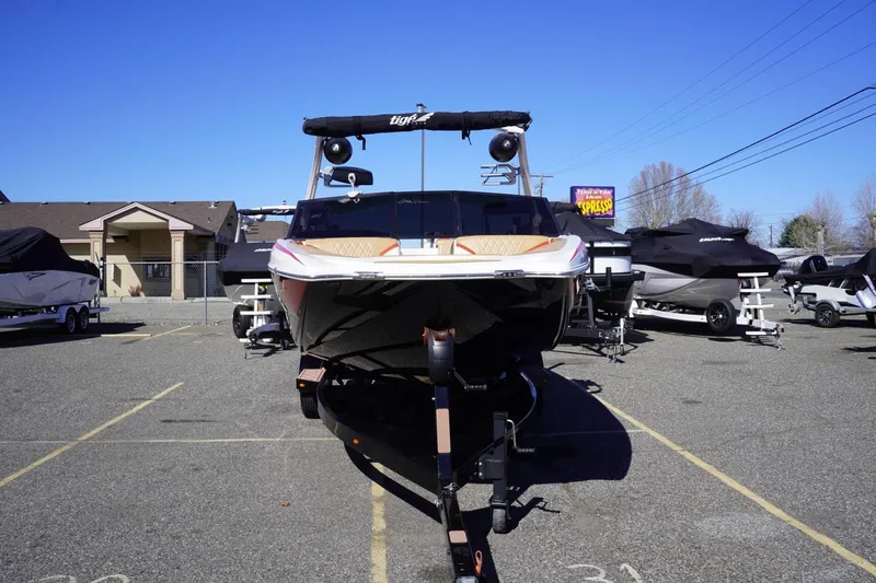 Slide: The Image of 2022 Tigé 22RZX boat on trailer in parking lot under clear blue sky. - 3