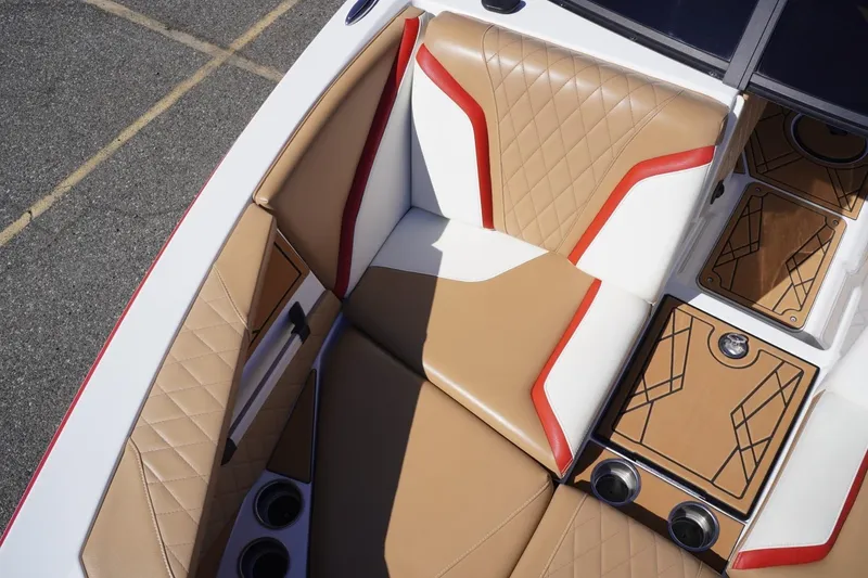 Slide: The Image of 2022 Tigé 22RZX boat interior with tan and white leather seats, red accents, and cup holders. - 33