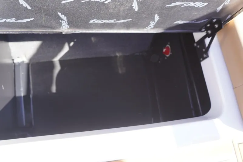 Slide: The Image of Open storage compartment in 2022 Tigé 22RZX boat, featuring branded interior lining. - 47