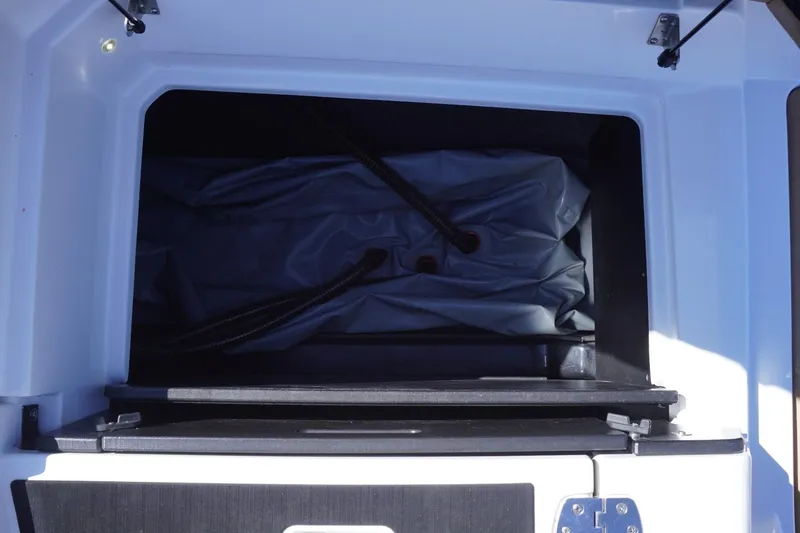 Slide: The Image of Storage compartment of 2022 Tigé 22RZX boat, featuring interior hoses and equipment. - 50
