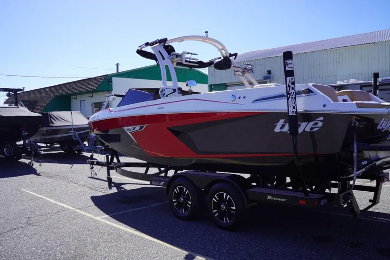 Slide: The Image of 2022 Tigé 22RZX boat on trailer, parked outdoors in a lot. - 6