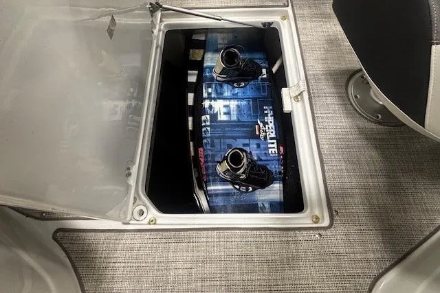 Slide: The Image of 2019 Crownline Eclipse E255 SURF boat storage compartment with wakeboard inside. - 25