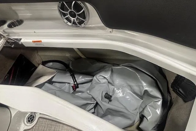 Slide: The Image of Storage compartment of 2019 Crownline Eclipse E255 SURF boat with speaker and inflatable equipment. - 28