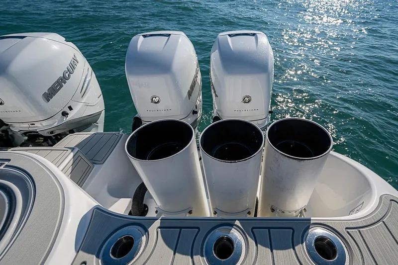 Slide: The Image of Four Mercury outboard engines on a 2018 Invincible 40 Catamaran, glistening on the ocean. - 13