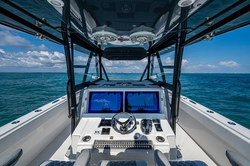 Slide: The Image of Cockpit view of 2018 Invincible 40 Catamaran on open sea, featuring modern navigation equipment. - 25