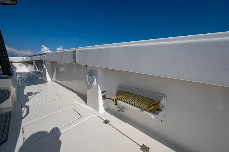 Slide: The Image of Invincible 40 Catamaran 2018 deck view with hose storage and speaker, under clear blue sky. - 27