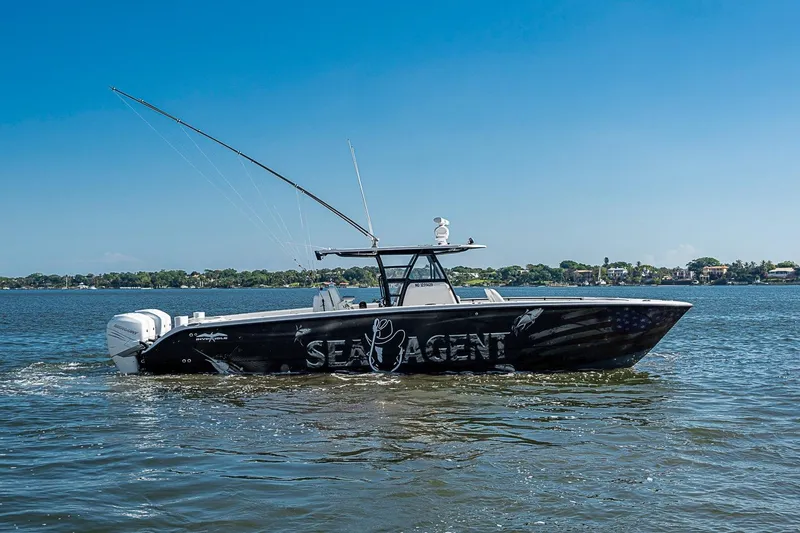 Slide: The Image of 2018 Invincible 40 Catamaran on water, clear sky, distant shoreline. - 32