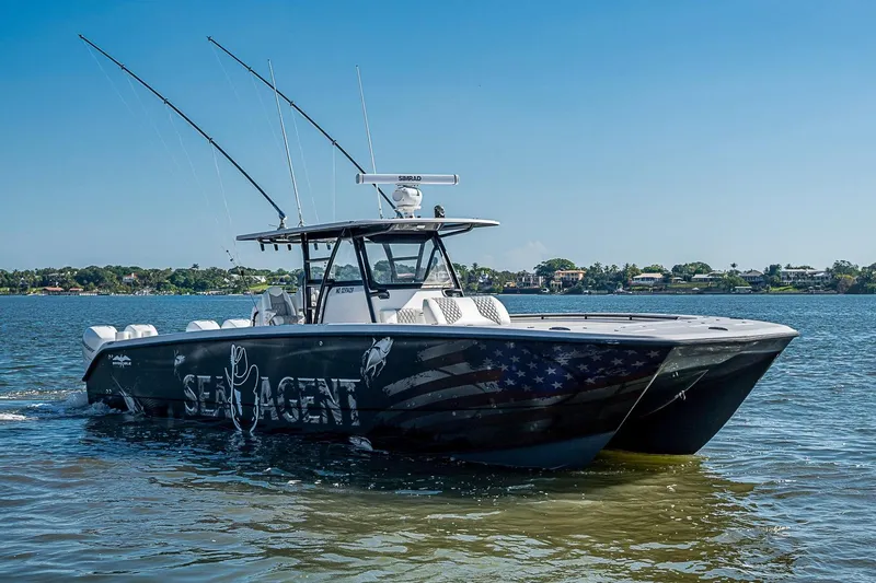 Slide: The Image of 2018 Invincible 40 Catamaran on water, featuring fishing rods and custom graphics. - 34