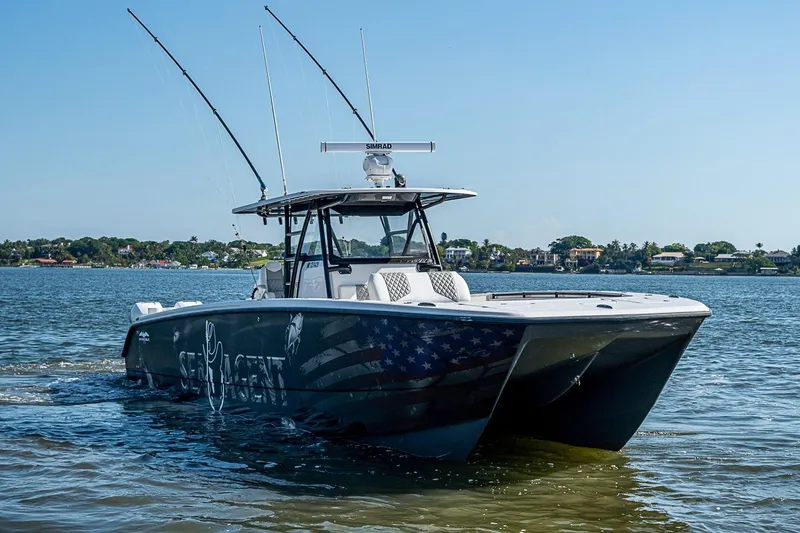 Slide: The Image of 2018 Invincible 40 Catamaran cruising on a sunny day, featuring fishing rods and sleek design. - 35