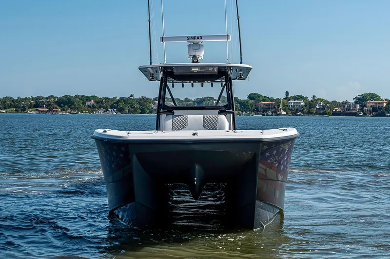 Slide: The Image of 2018 Invincible 40 Catamaran on calm water, front view with clear sky background. - 36
