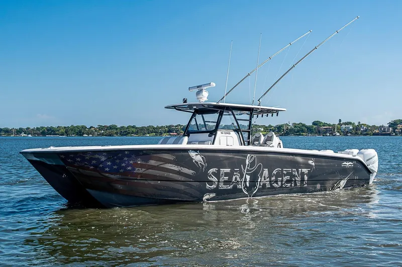 Slide: The Image of Invincible 40 Catamaran 2018 on water, featuring custom "Sea Agent" design. - 38