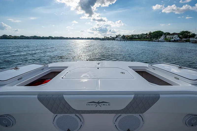 Slide: The Image of Invincible 40 Catamaran 2018 on serene water with clear sky and distant shoreline. - 4