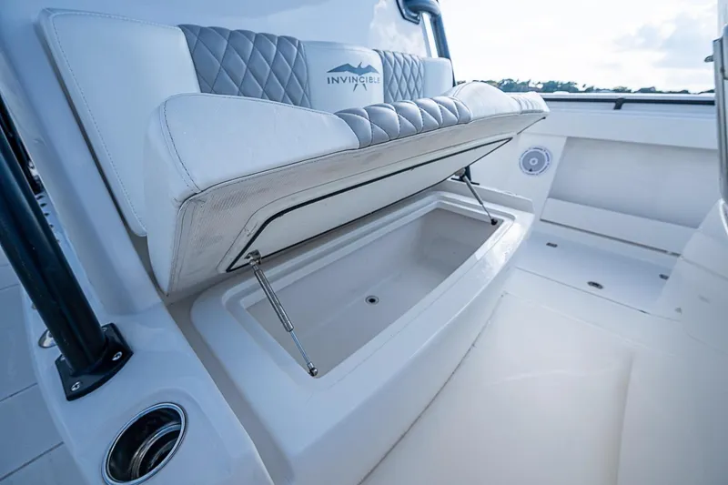Slide: The Image of 2018 Invincible 40 Catamaran seat storage compartment, open with cushioned seating above. - 7
