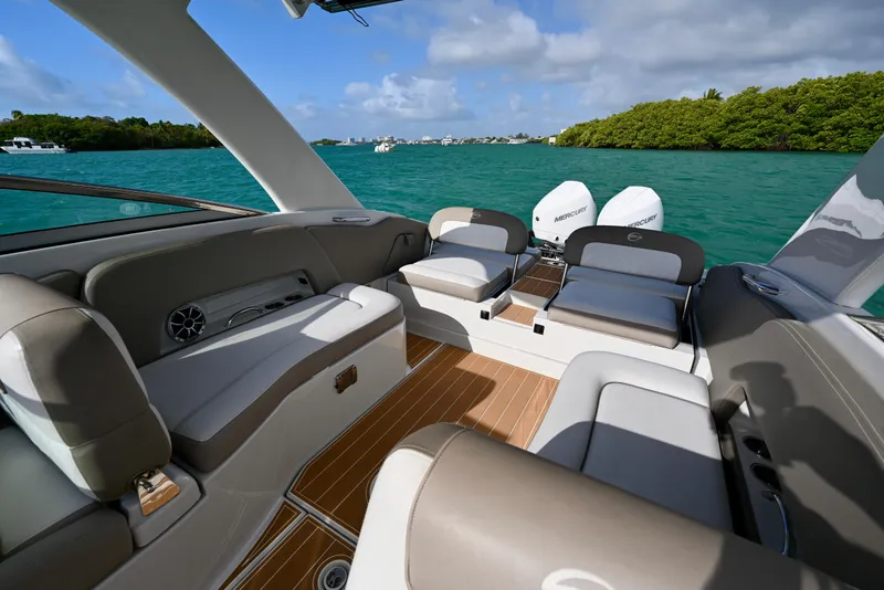 Slide: The Image of 2020 Crownline Eclipse E305 XS boat interior with luxurious seating on turquoise water. - 10