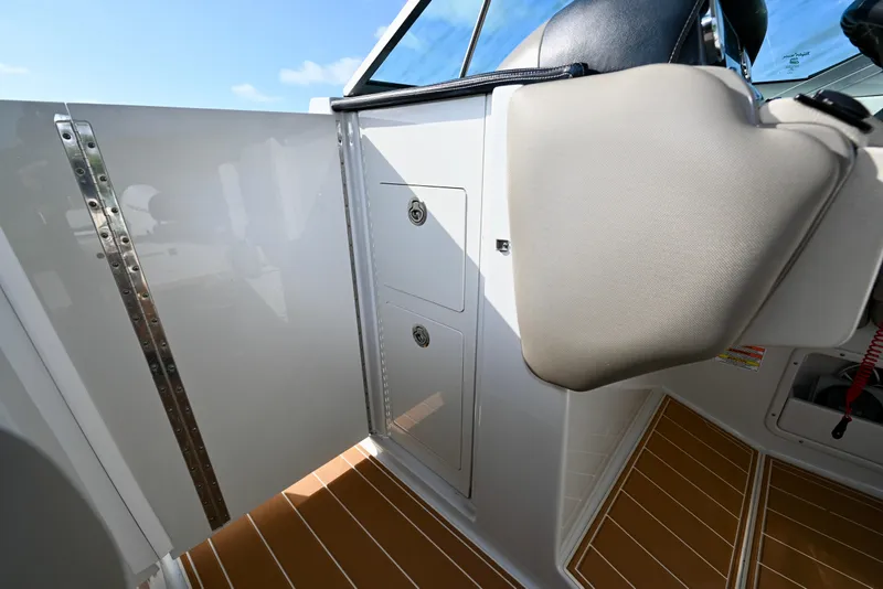 Slide: The Image of 2020 Crownline Eclipse E305 XS boat interior with storage compartments and cushioned seating. - 22