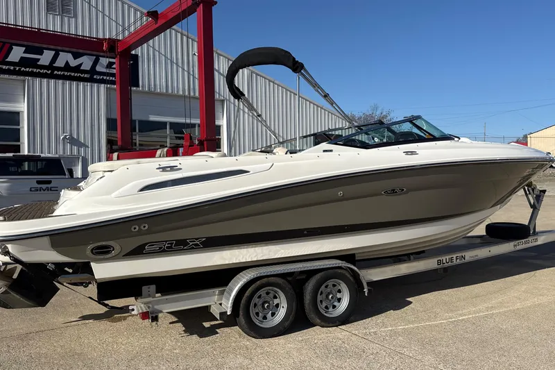 Slide: The Image of 2007 Sea Ray 250 Select EX boat on trailer outside marine facility. - 2