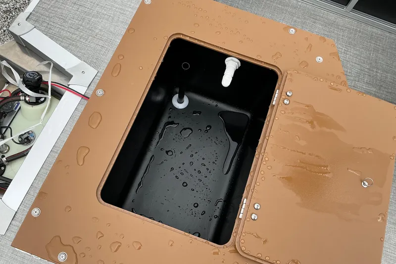 Slide: The Image of Open storage compartment on 2026 Avalon Venture Rear Fish boat, showing interior and wiring. - 11