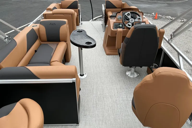 Slide: The Image of 2026 Avalon Venture Rear Fish boat interior with tan and gray seating, steering console, and table. - 12