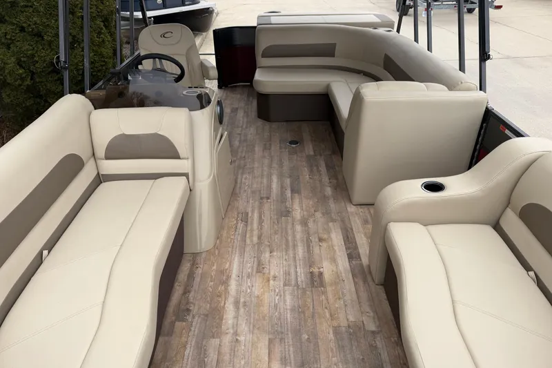 Slide: The Image of 2018 Crest I pontoon boat interior with beige seating and wood-style flooring. - 5