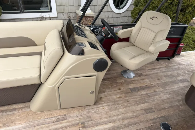 Slide: The Image of 2018 Crest I boat interior with beige seating and wood-style flooring. - 9