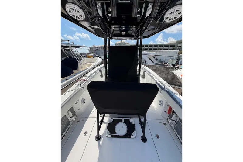 Slide: The Image of 2018 Blackfin 242 CC boat interior with seating, docked in a marina. - 16