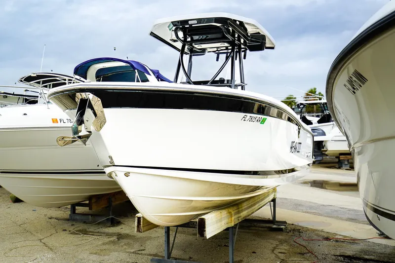 Slide: The Image of 2018 Blackfin 242 CC boat on display in a marina, surrounded by other vessels. - 2