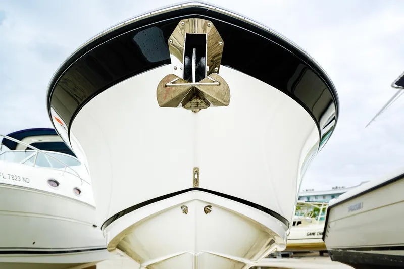 Slide: The Image of 2018 Blackfin 242 CC boat with sleek design and anchor, docked among other vessels. - 27