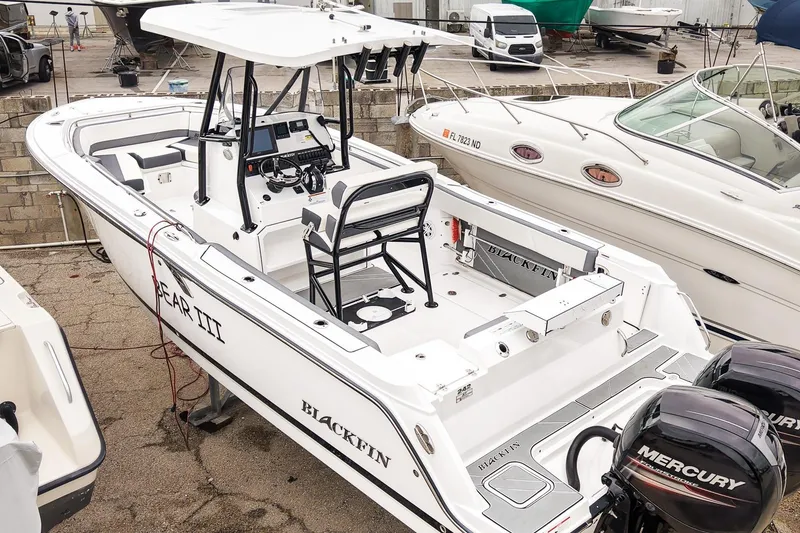 Slide: The Image of 2018 Blackfin 242 CC boat with dual Mercury engines, docked in a marina. - 28