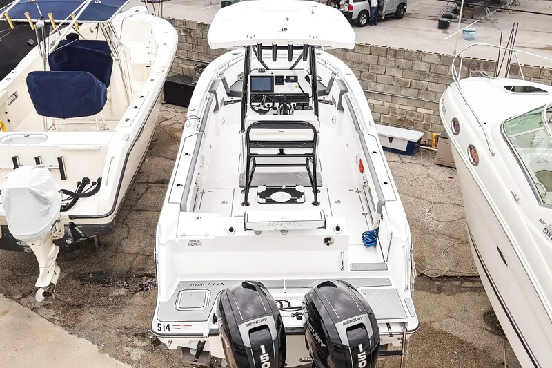 Slide: The Image of 2018 Blackfin 242 CC boat with dual Mercury engines, docked among other vessels. - 29