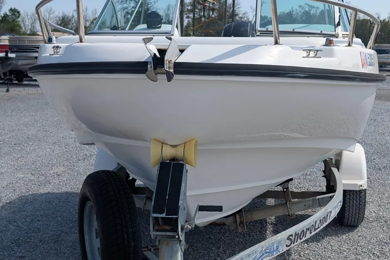 Slide: The Image of 1998 Boston Whaler Ventura 20 boat on trailer, front view, parked on gravel. - 2