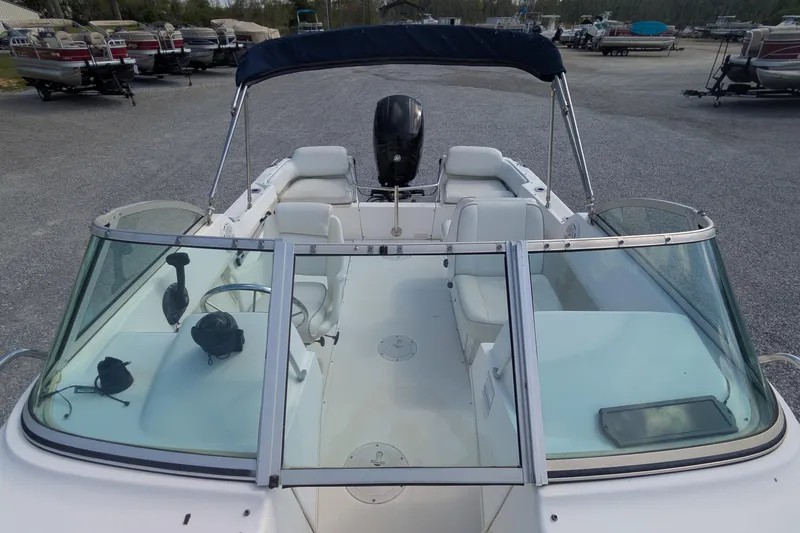Slide: The Image of 1998 Boston Whaler Ventura 20 boat with open deck and windshield, parked on gravel. - 4