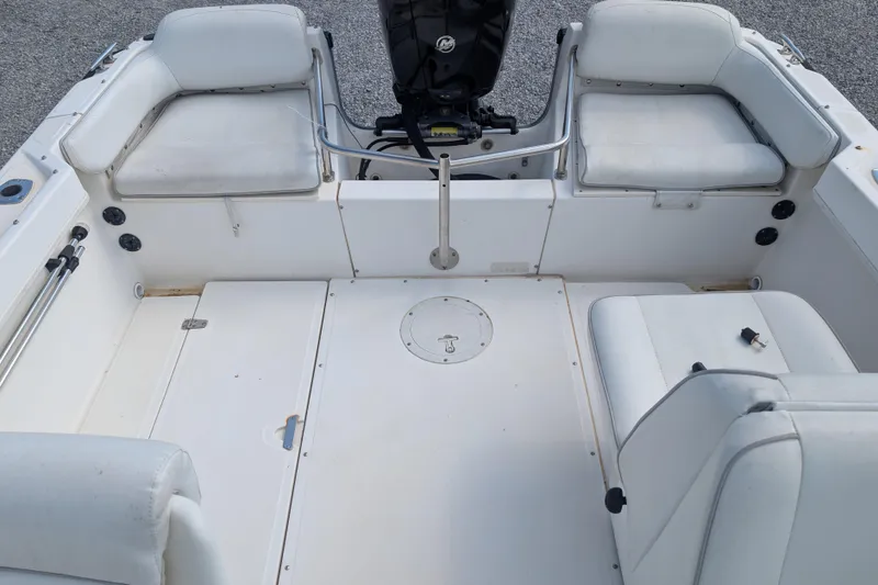 Slide: The Image of 1998 Boston Whaler Ventura 20 boat interior with white seating and motor. - 8
